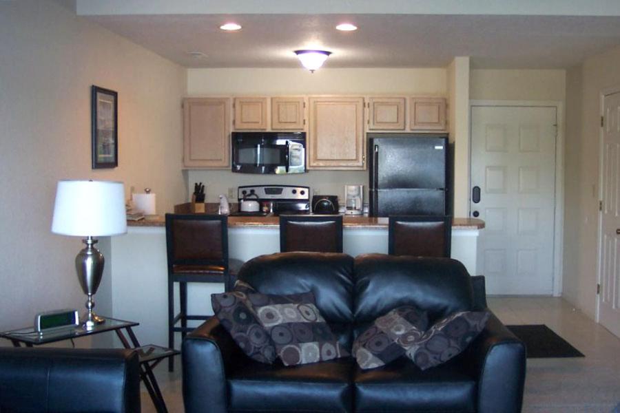 a living room with a couch and a kitchen at Regatta Bay in Lake Ozark