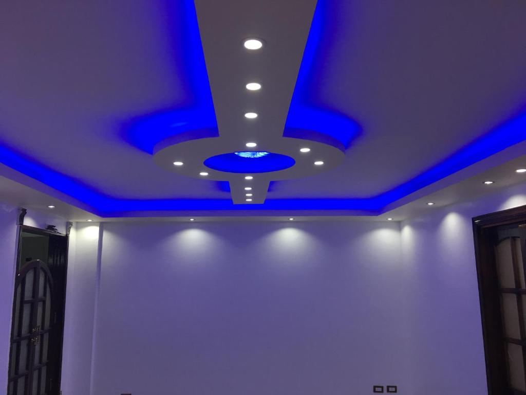 un soffitto con luci blu in una stanza di Al Marwa Apartment in Dokki - Families Only a Il Cairo