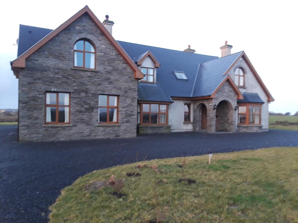 a large stone house with a large driveway at Bealaha House in Doonbeg