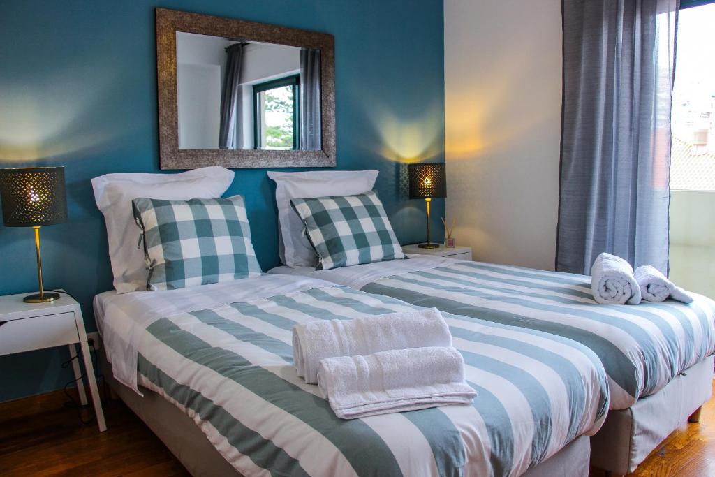 a bedroom with two beds and a mirror on the wall at Alameda Garden in Faro
