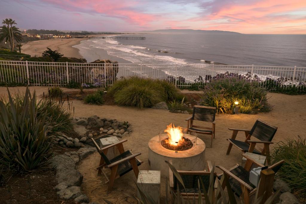 a fire pit on a patio next to the beach at Cottage Inn by the Sea in Pismo Beach