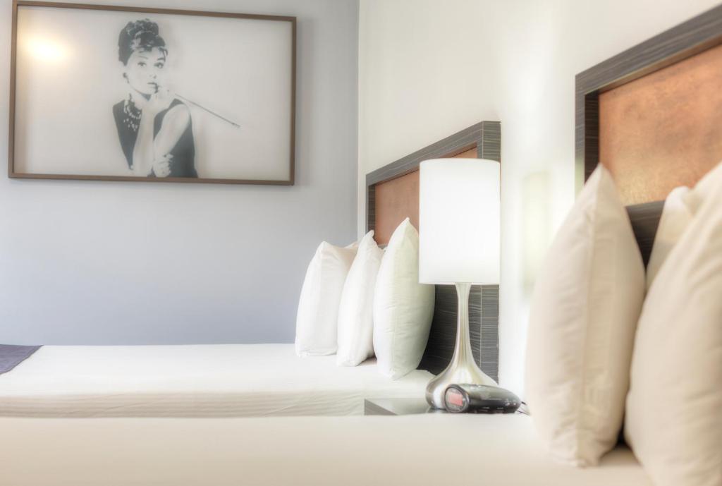 a hotel room with two beds and a picture of a man at Hotel Ruby in Spokane