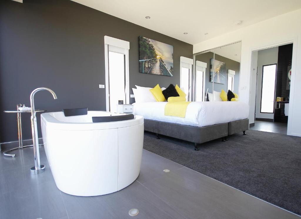 a bedroom with a large bed and a bath tub at Horizon Deluxe Apartments in Stanley