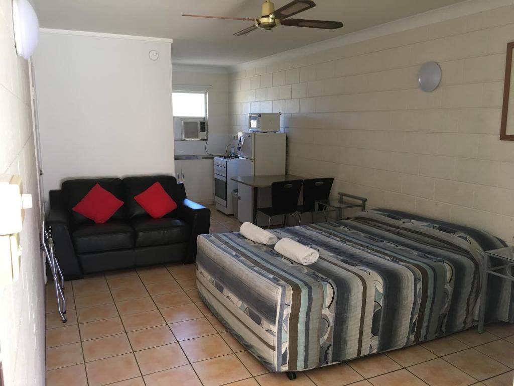 a living room with a bed and a couch at Oasis Inn Apartments in Cairns