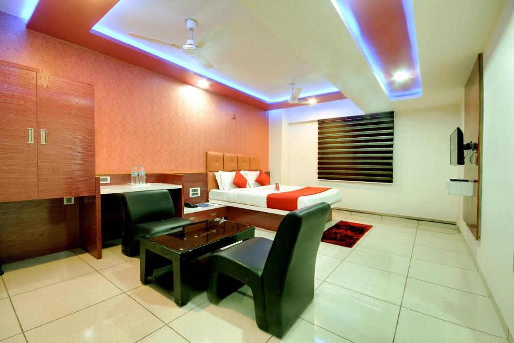 a hotel room with a bed and a desk and a desk at Hotel Hillton Inn in Gandhinagar