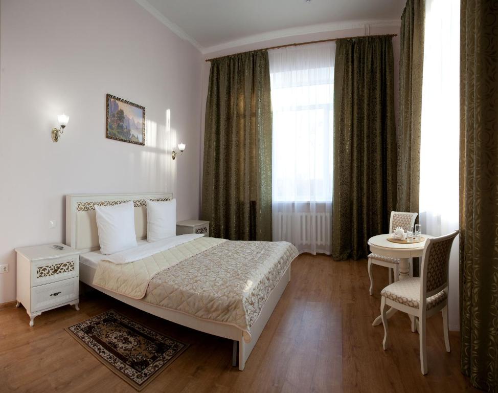 1 dormitorio con 1 cama, 1 mesa y 1 silla en Гостевая усадьба"Никольская", en Tyumen