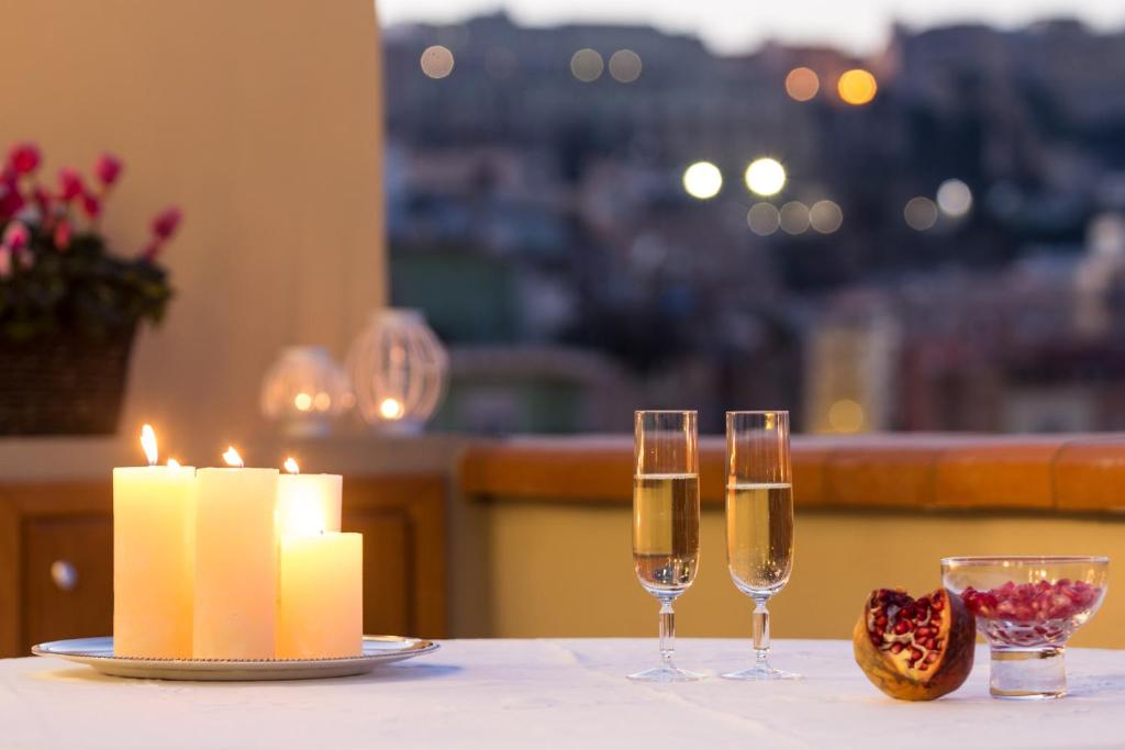 a table with two glasses of champagne and a candle at Elafi Penthouse in Cagliari