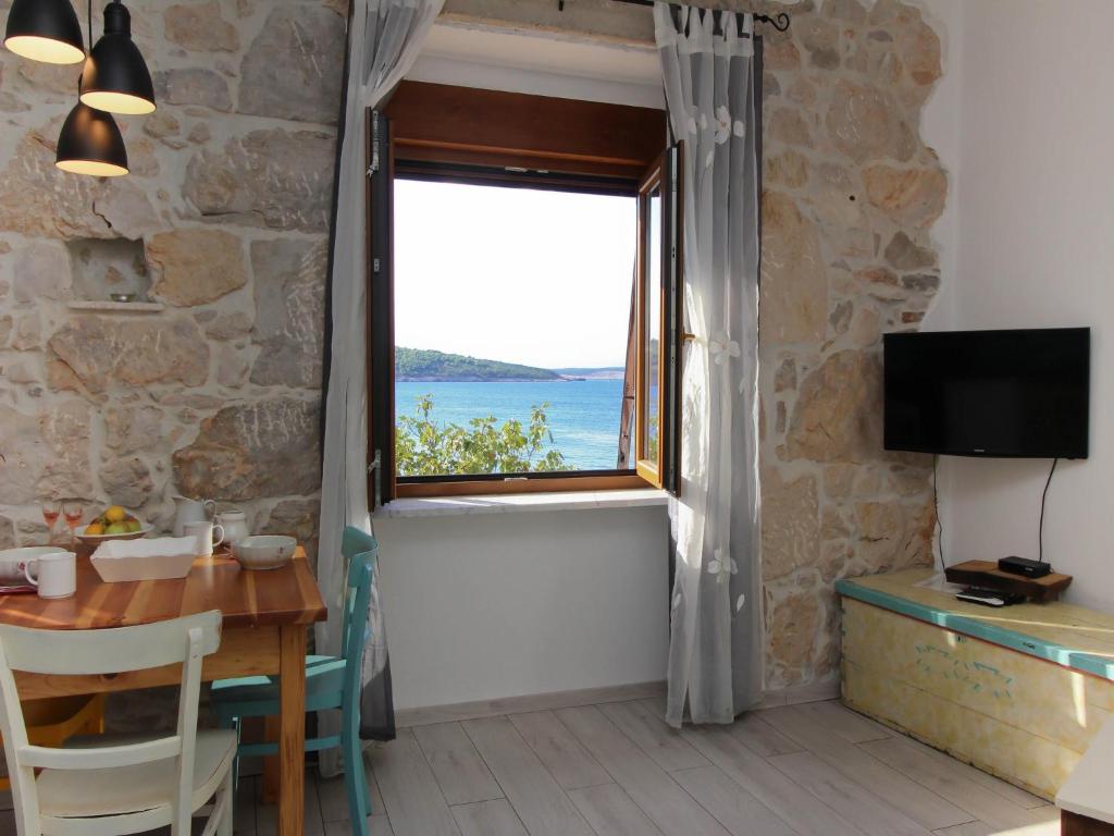 Cette chambre dispose d'une table et d'une grande fenêtre. dans l'établissement Apartments Gorisek, à Šilo