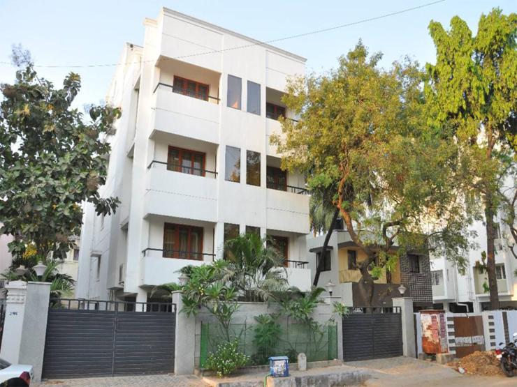 un edificio blanco con una valla delante en Phoenix Serviced Apartment - Anna Nagar en Chennai