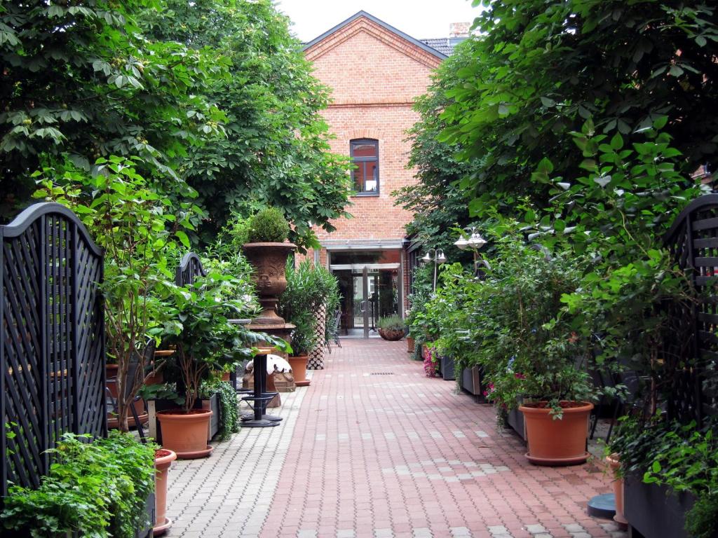 a brick walkway with potted plants in front of a building at Hotel Fabrik Vösendorf in Vösendorf