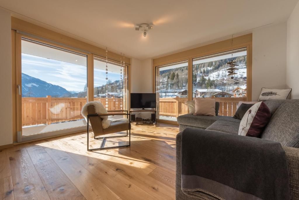 een woonkamer met een bank en een tafel met een televisie bij Zer Milachra in Fiesch