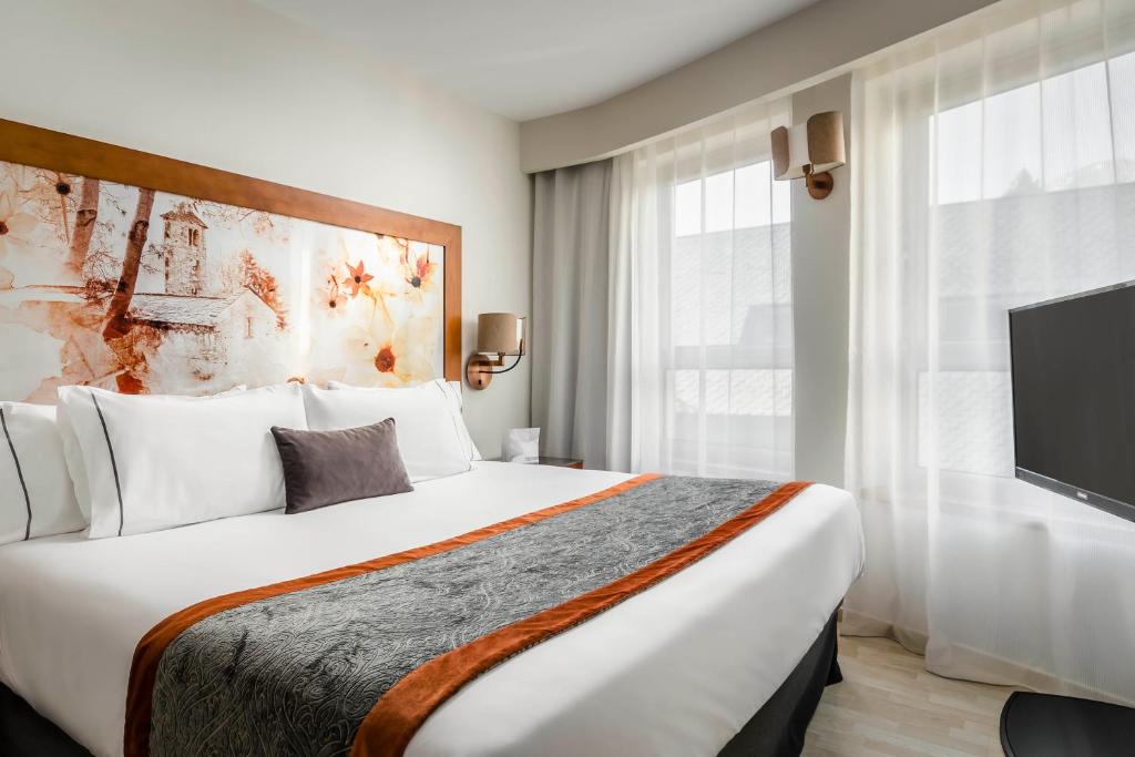 een hotelkamer met een groot bed en een televisie bij Eurostars Andorra in Andorra la Vella