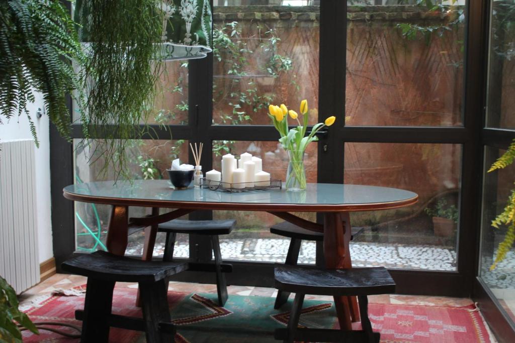 - une table avec des fleurs et des bougies sur la terrasse dans l'établissement Little Garden, à Trévise