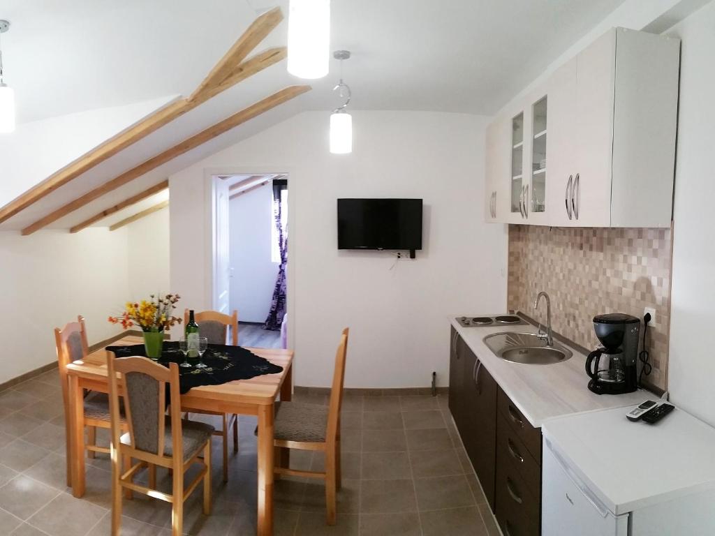 eine Küche und ein Esszimmer mit einem Tisch und einem Waschbecken in der Unterkunft Apartmani Marijana in Šibenik
