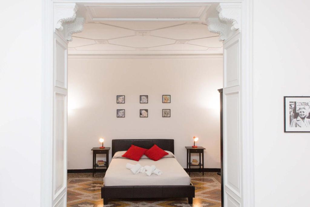 1 dormitorio con 1 cama con almohadas rojas en Leone X Genova Affittacamere, en Génova