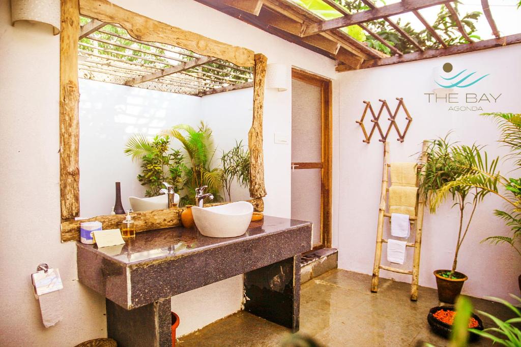 a bathroom with two sinks and a mirror at The Bay Agonda in Agonda