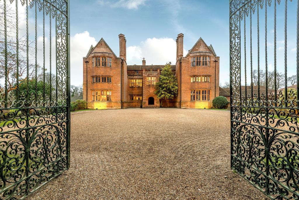 an open gate to a large building with a courtyard at New Place in Fareham