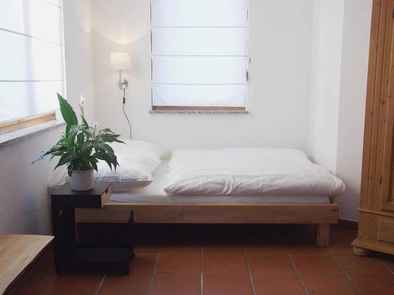 a bed in a room with a potted plant at Ferienwohnung Design Apartment Seoul in Radolfzell am Bodensee