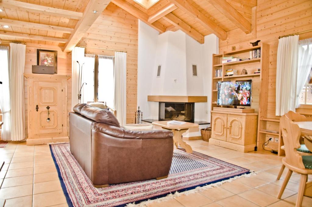 ein Wohnzimmer mit einem Ledersofa und einem Kamin in der Unterkunft Apartment St. Louis 3.5 - GriwaRent AG in Grindelwald