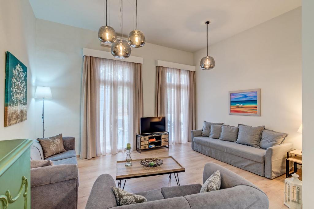 salon z kanapą i telewizorem w obiekcie Grande Casa 1926 w Chanii