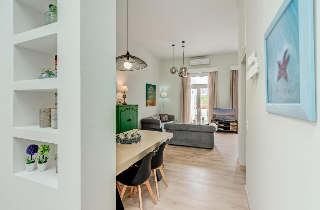 jadalnia i salon ze stołem i krzesłami w obiekcie Grande Casa 1926 w Chanii