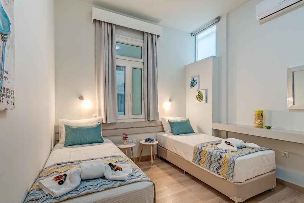 dwa łóżka w pokoju z dwoma oknami w obiekcie Grande Casa 1926 w Chanii