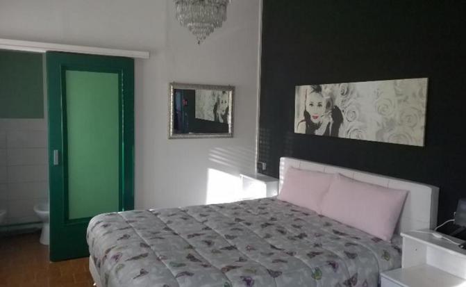una camera con un letto e una porta verde di B&B PORTA APPIA a Imola