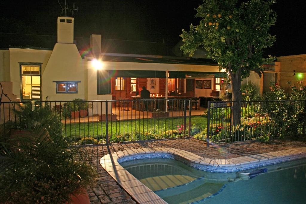 a house with a swimming pool at night at Thyme and Again Bed and Breakfast in Graaff-Reinet