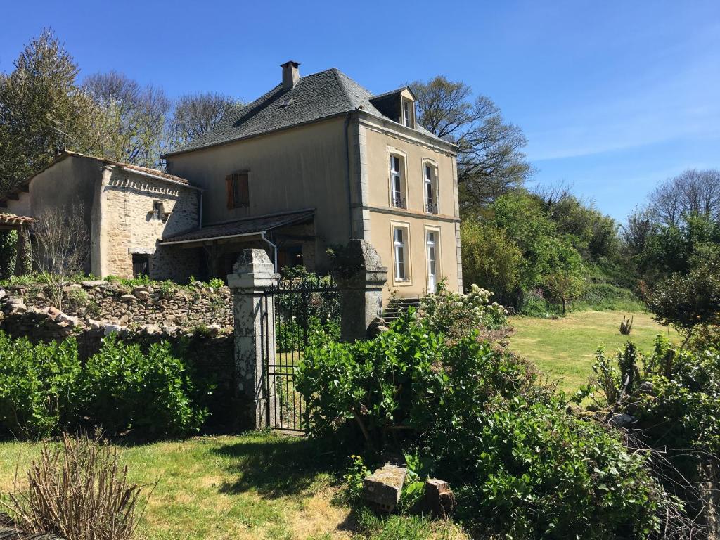 une maison ancienne avec un portail dans un champ dans l'établissement L'Enquenoiulle Basse, à Verdun-en-Lauragais