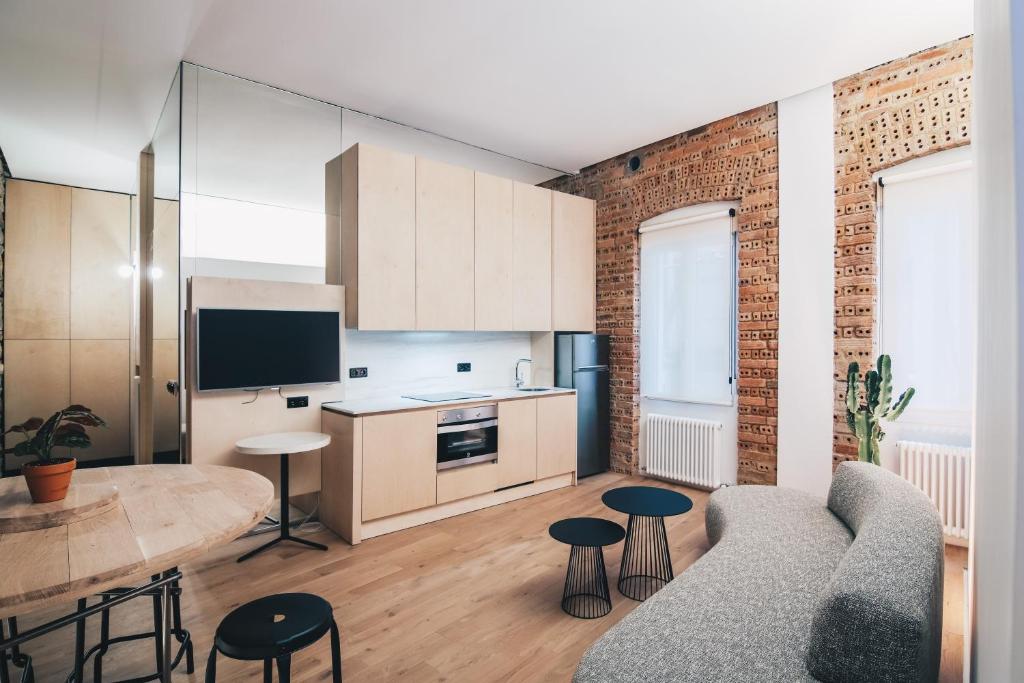 eine Küche und ein Wohnzimmer mit einem Sofa und einem Tisch in der Unterkunft Moyua Apartment by People Rentals in Bilbao