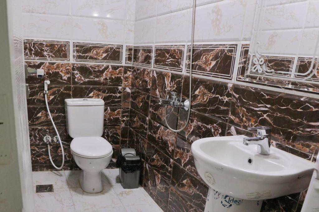 y baño con aseo y lavamanos. en Hostgram Hotel en El Cairo
