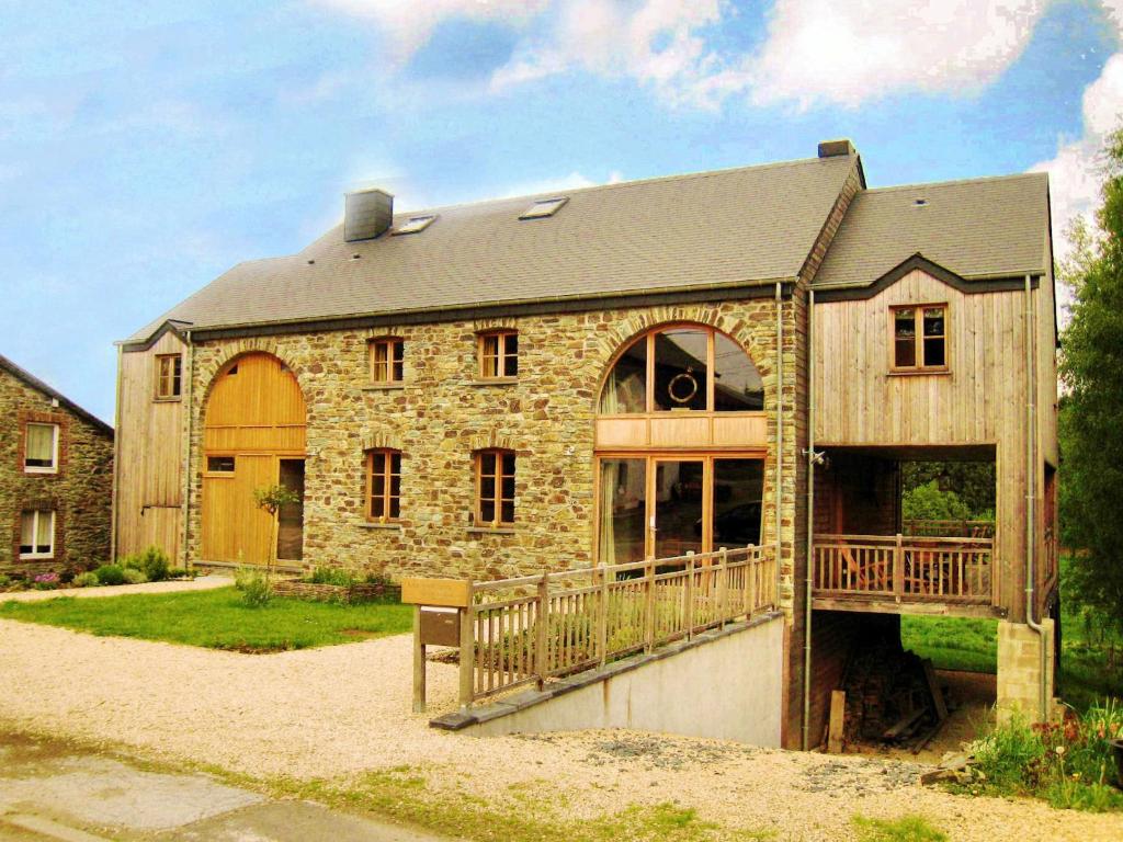 a stone house with a porch and a balcony at Fort like Holiday Home in Sart Bertrix a drive away from Luxembourg in Sart