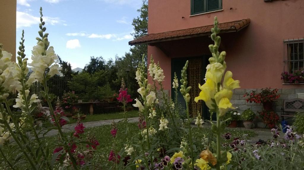 a garden with flowers in front of a house at La Torretta bed & breakfast in Torriglia