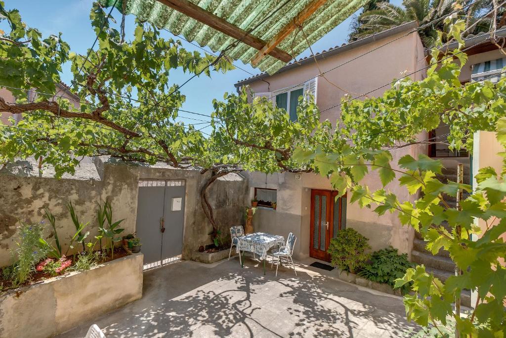 a courtyard of a house with a table and chairs at Apartments Ivna in Veli Lošinj