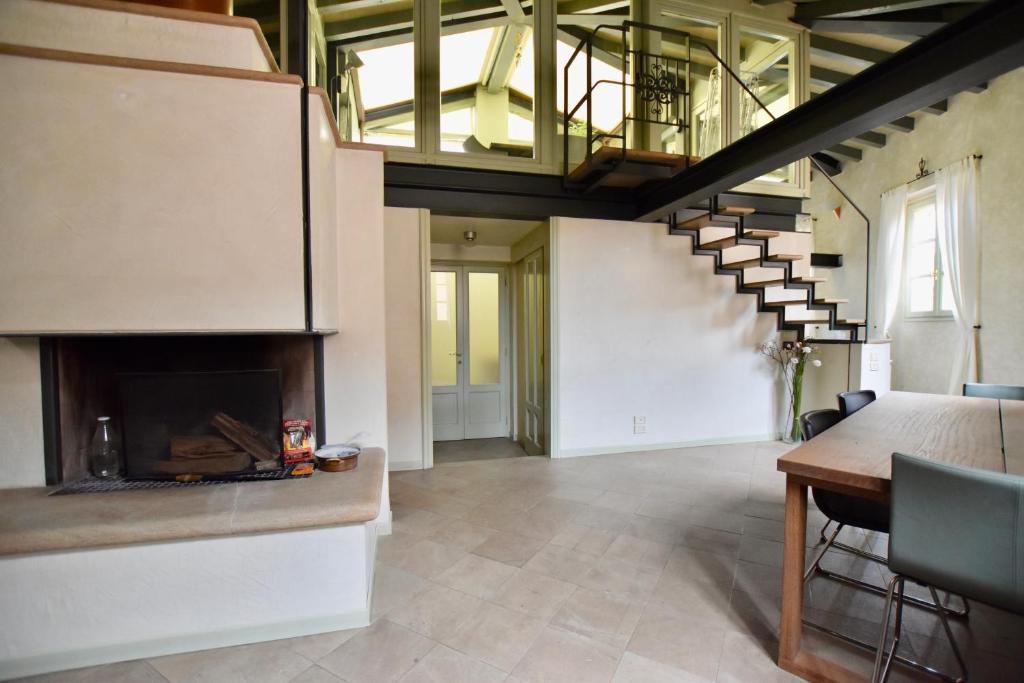 a living room with a fireplace and a table at Via Sambuco in Iseo