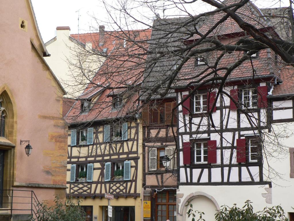 une vieille maison avec volets rouges sur un bâtiment dans l'établissement Au Chasseur, à Colmar