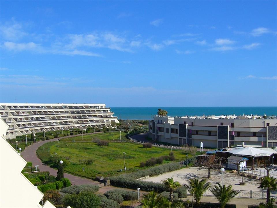 uma vista para um edifício com o oceano ao fundo em Cap Nat International - Natura Beach Village Naturiste em Cap d'Agde