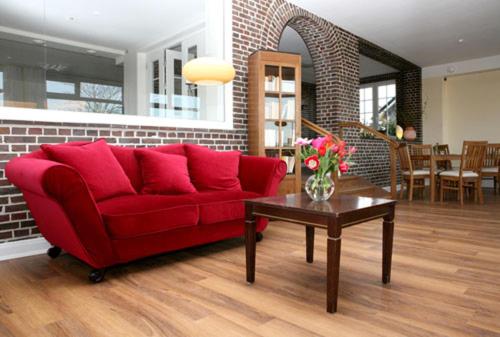 a living room with a red couch and a table at Haus am Meer in Scharbeutz
