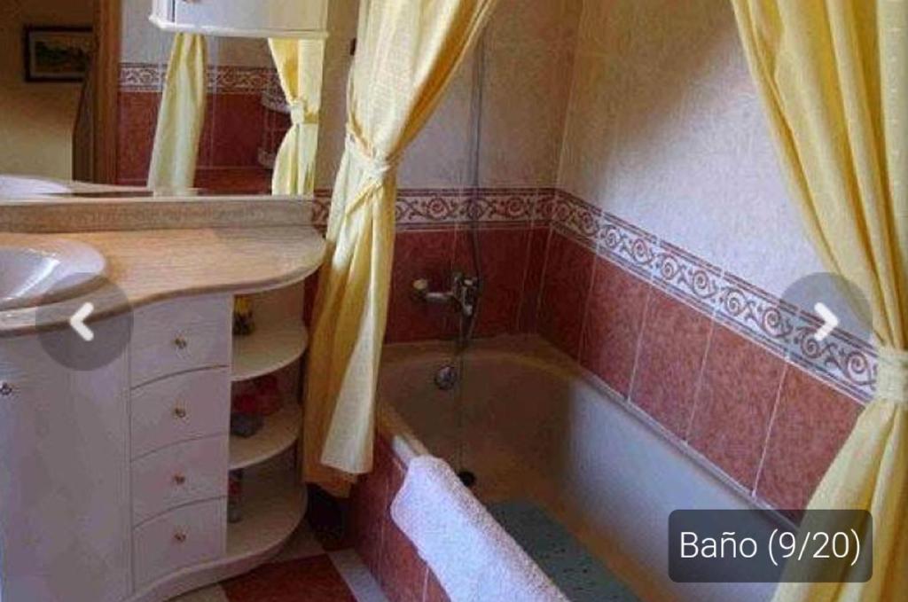 a bathroom with a bath tub and a sink at Casa _pareada con piscina y jardin privado in Torredembarra