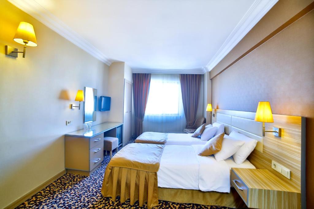 a hotel room with a large bed and a desk at Hotel Grand Emin in Istanbul