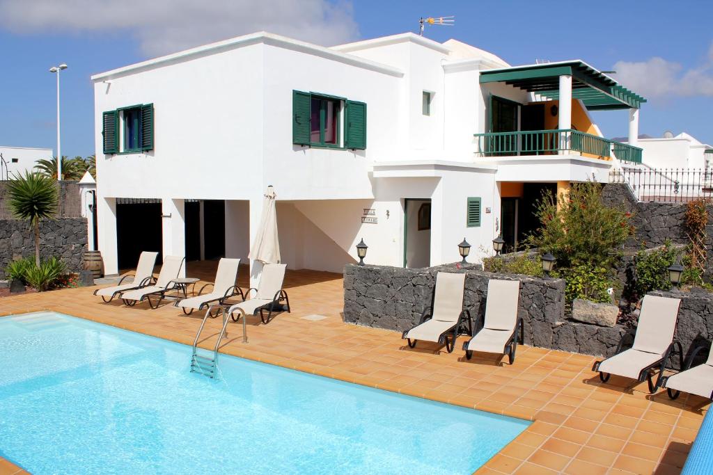 une villa avec une piscine en face d'une maison dans l'établissement Villa LEONARD, à Playa Blanca