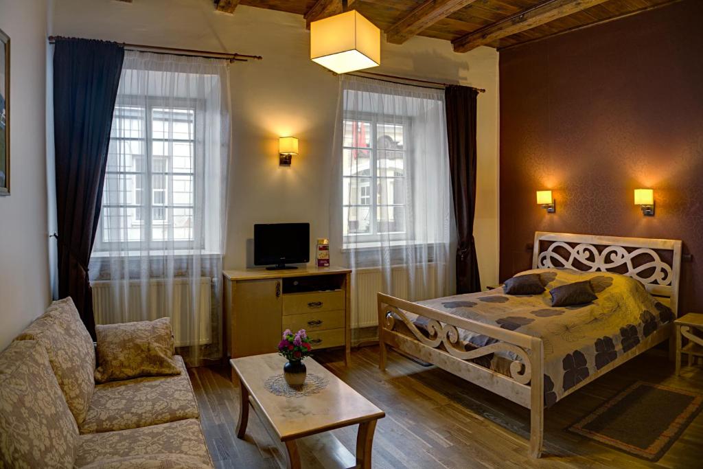 1 dormitorio con 1 cama, 1 sofá y 1 silla en Bernardinu B&B House, en Vilna