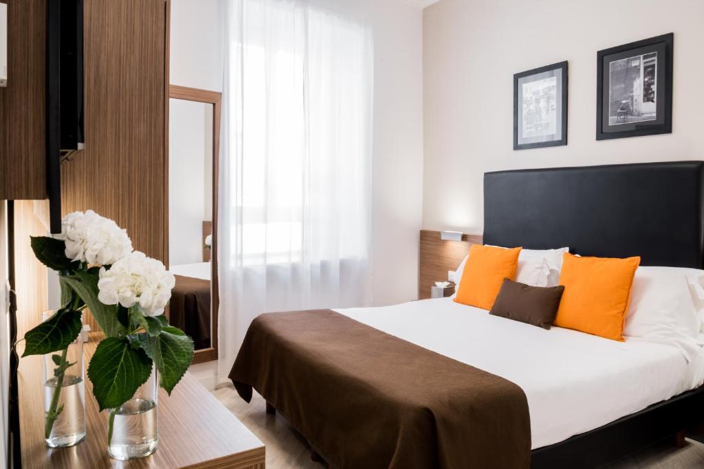 ein Schlafzimmer mit einem Bett und einer Vase aus Blumen in der Unterkunft Hotel Concordia in Rom