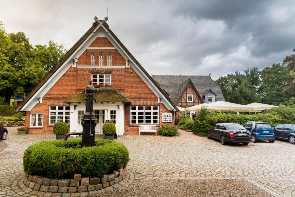 a brick house with cars parked in front of it at Hotel Alster Au in Duvenstedt