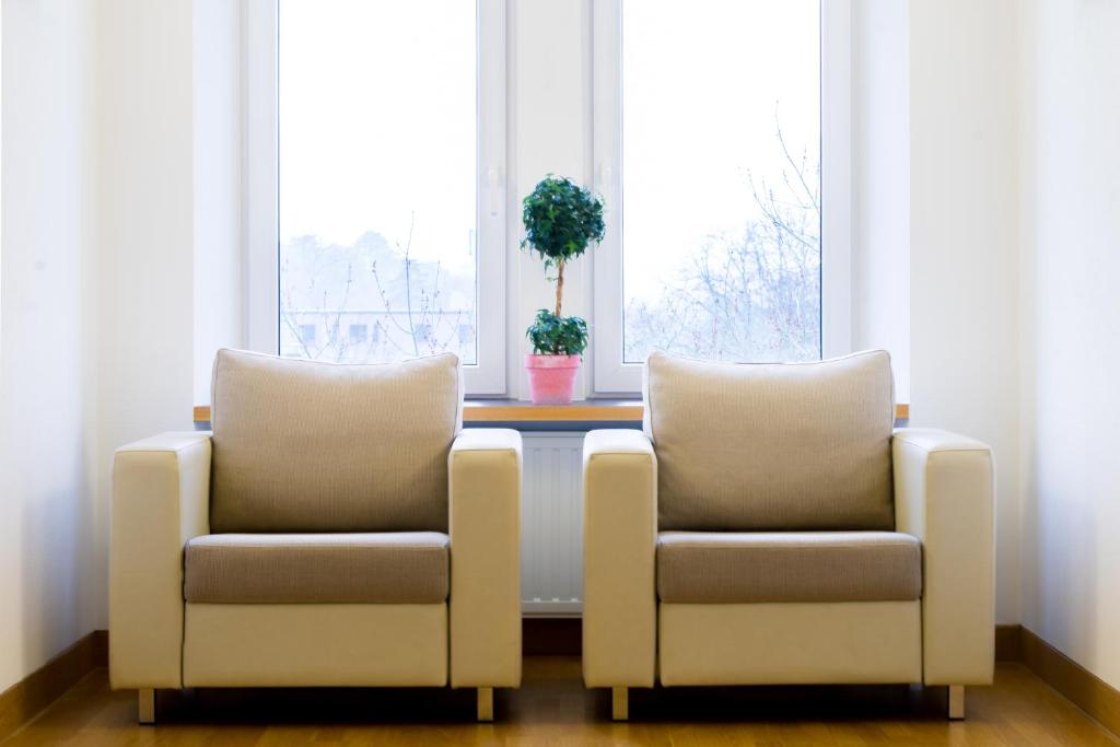 2 chaises assises à côté d'une table devant une fenêtre dans l'établissement Hotel-Résidence Am Klouschter, à Mondorf-les-Bains