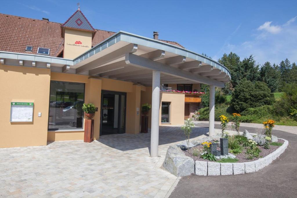 ein Gebäude mit Markise und Blumen davor in der Unterkunft Landhaus Lauble in Hornberg