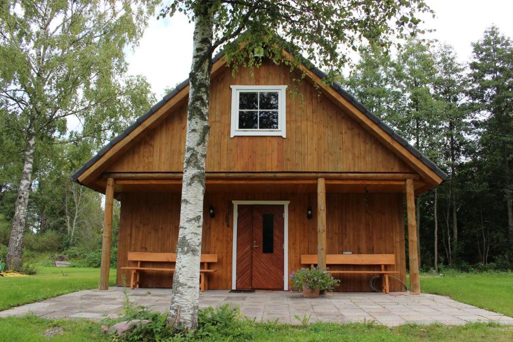 a large wooden building with a white window on it at Rannapera in Peraküla