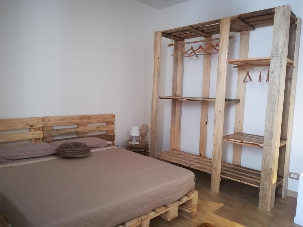 um quarto com uma cama e 2 prateleiras de madeira em amendola24 em Cefalù