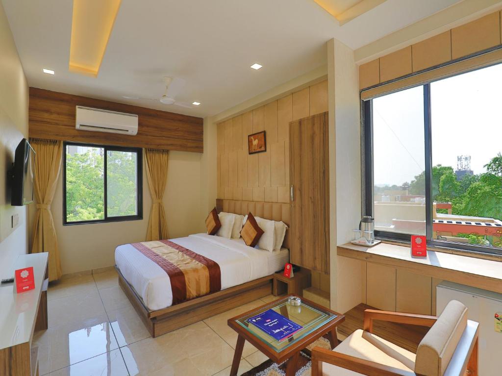 een hotelkamer met een bed en een raam bij Hotel Repose in Ahmedabad