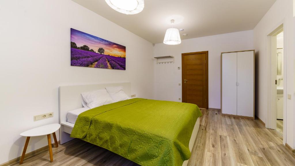 sypialnia z zielonym łóżkiem w pokoju w obiekcie Riga Airport Jurmala apartments w Rydze